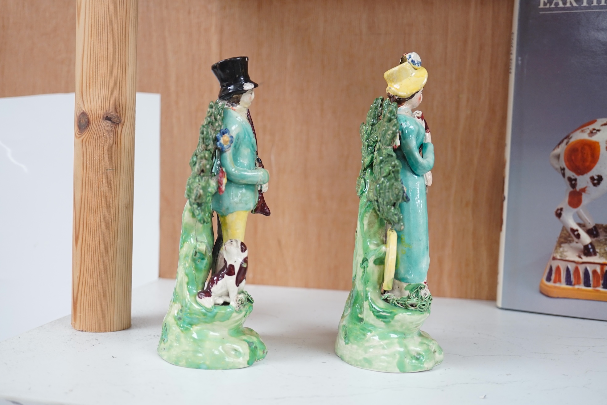 A pair of early 19th century pearlware figures of a huntsman and a female archer, 19.5cm high. Condition - some restoration otherwise in reasonable condition